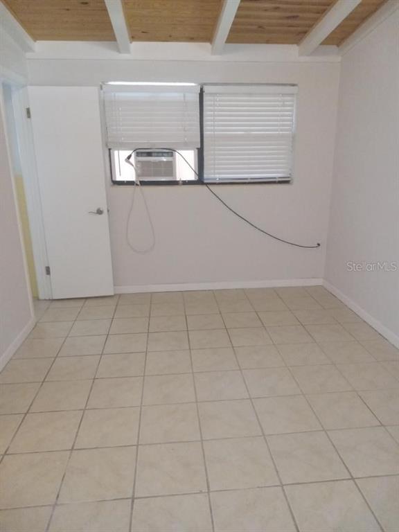 A room with tiled floors, a white door, and a window air conditioning unit — 1117 PATTERSON DRIVE UNIT Front, SARASOTA, FL