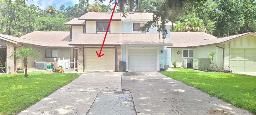 A two-story duplex with two garage doors, light-colored siding, and a shared concrete driveway — 836 SUGAR HOUSE DRIVE, PORT ORANGE, FL