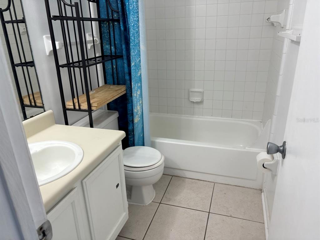 A bathroom features a vanity, a toilet, and a bathtub with white tiled walls — 2302 MAKI ROAD UNIT 25, PLANT CITY, FL