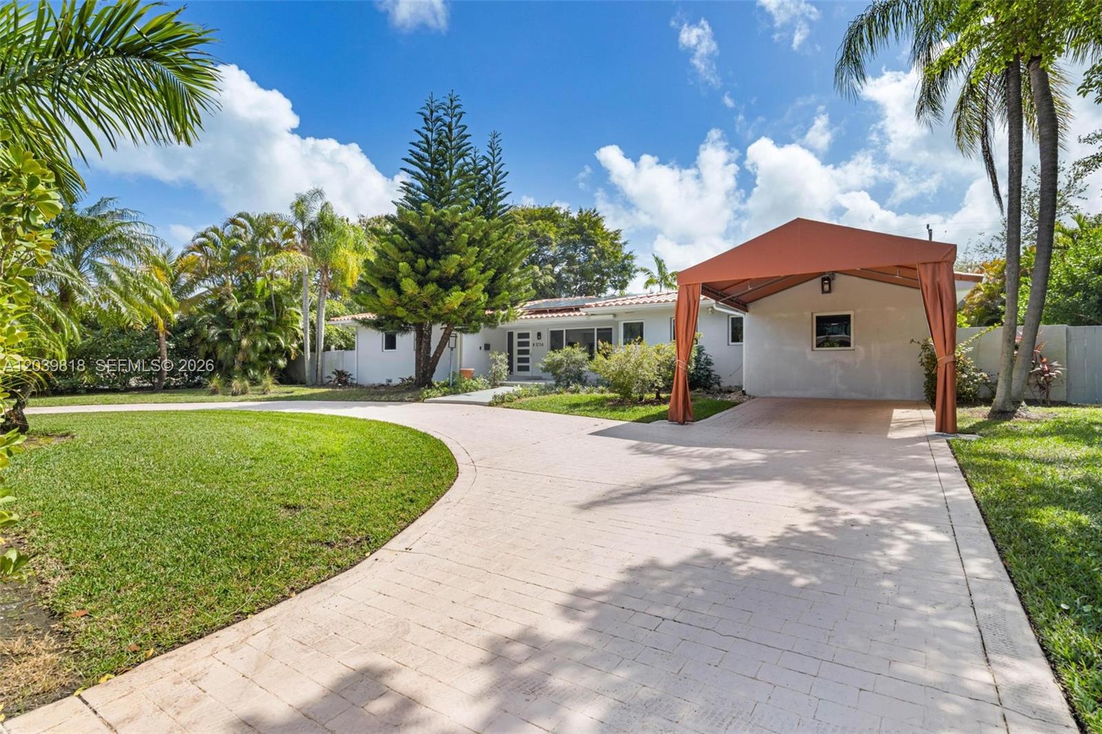 A single-story house with a paved driveway and a large orange fabric carport — 1014 Jefferson St, Hollywood FL 33019, HOLLYWOOD, FL