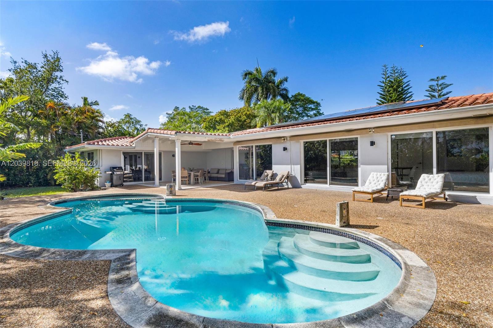 A backyard features a swimming pool with steps, a covered patio, and lounge chairs — 1014 Jefferson St, Hollywood FL 33019, HOLLYWOOD, FL