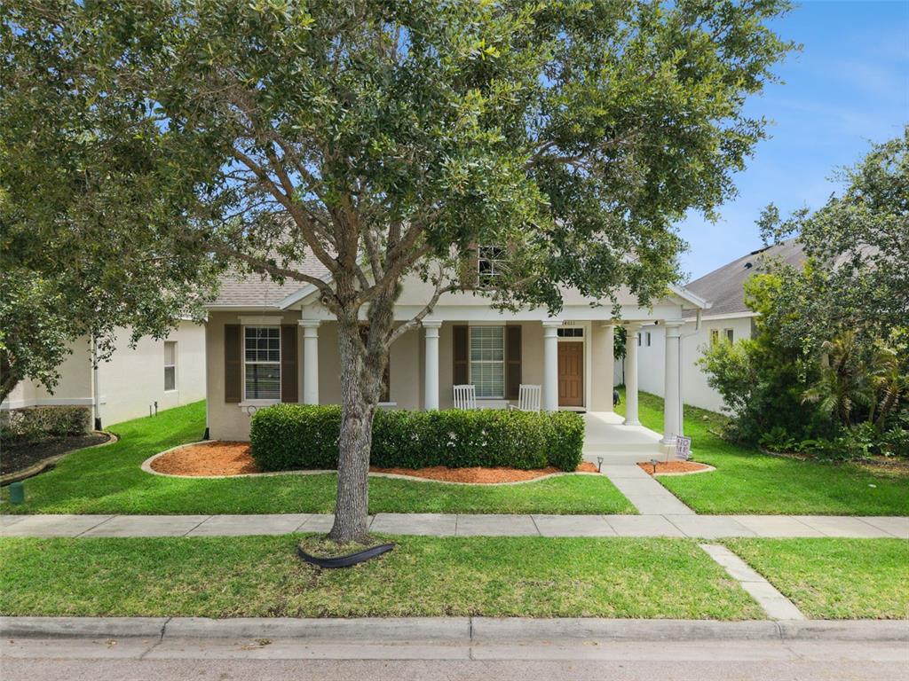 A single-story house with a front porch, columns, and a large tree in the yard — 14011 GOLDEN RAIN TREE BOULEVARD, ORLANDO, FL