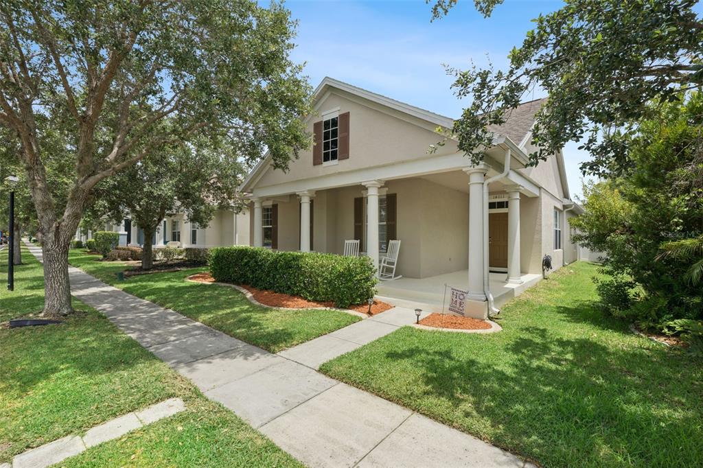 A single-story house with a covered front porch, columns, and a manicured hedge — 14011 GOLDEN RAIN TREE BOULEVARD, ORLANDO, FL