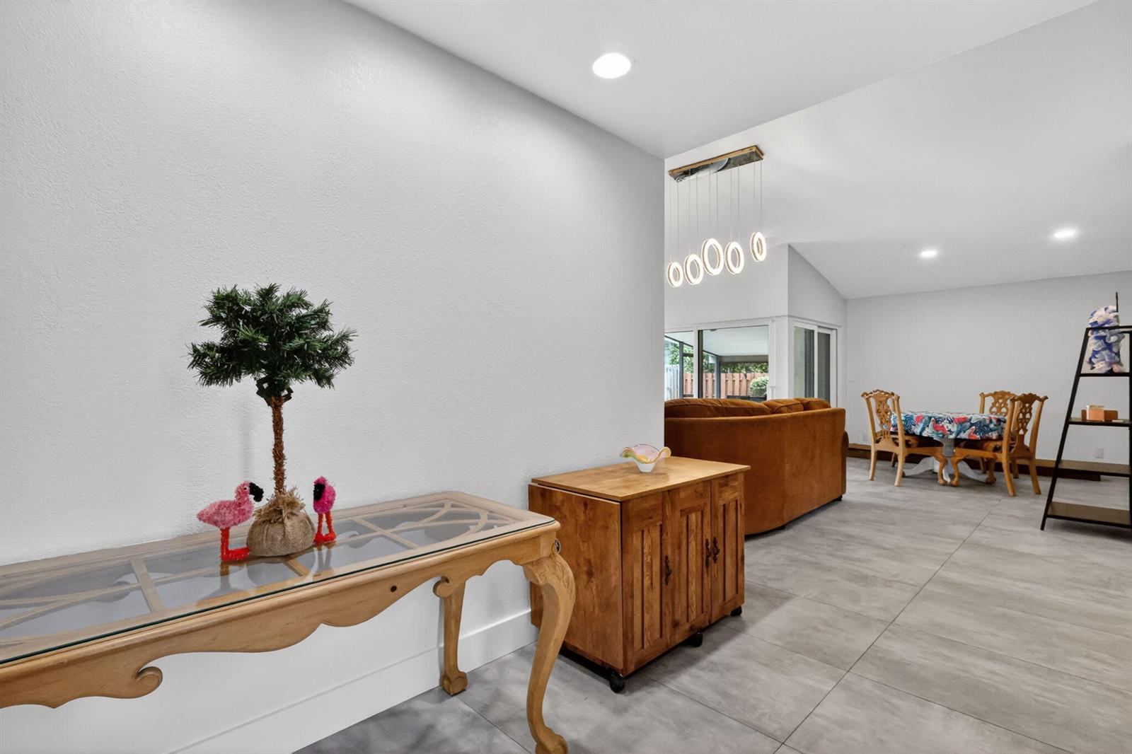 An entryway with a glass-topped console table leads into a living and dining area — 1230 NW 22nd Avenue, Delray Beach FL 33445, DELRAY BEACH, FL