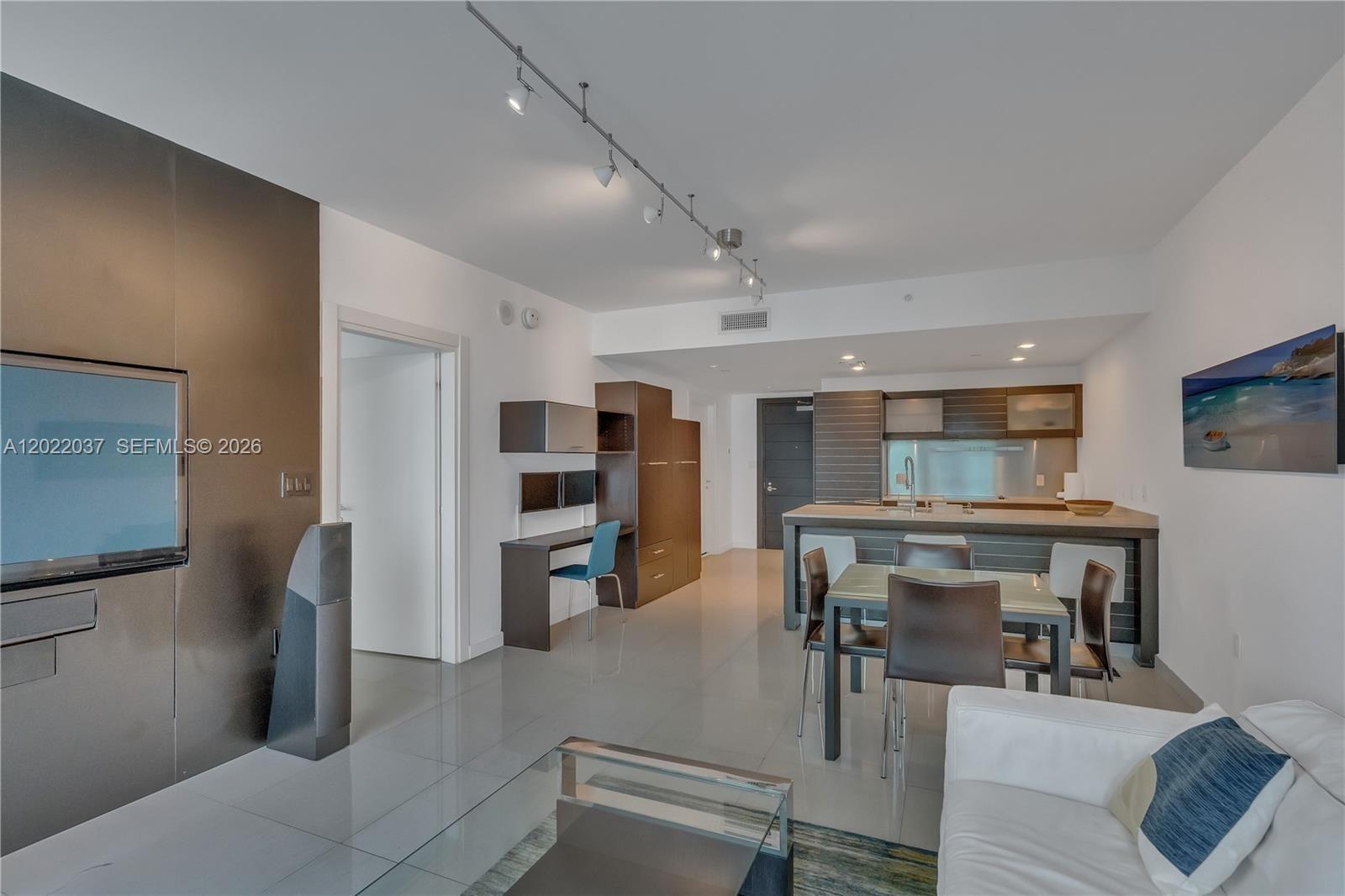 This open-concept living area features a kitchen, dining space, and office nook with tile floors — 200 Biscayne Boulevard Way # 3911, Miami FL 33131, MIAMI, FL