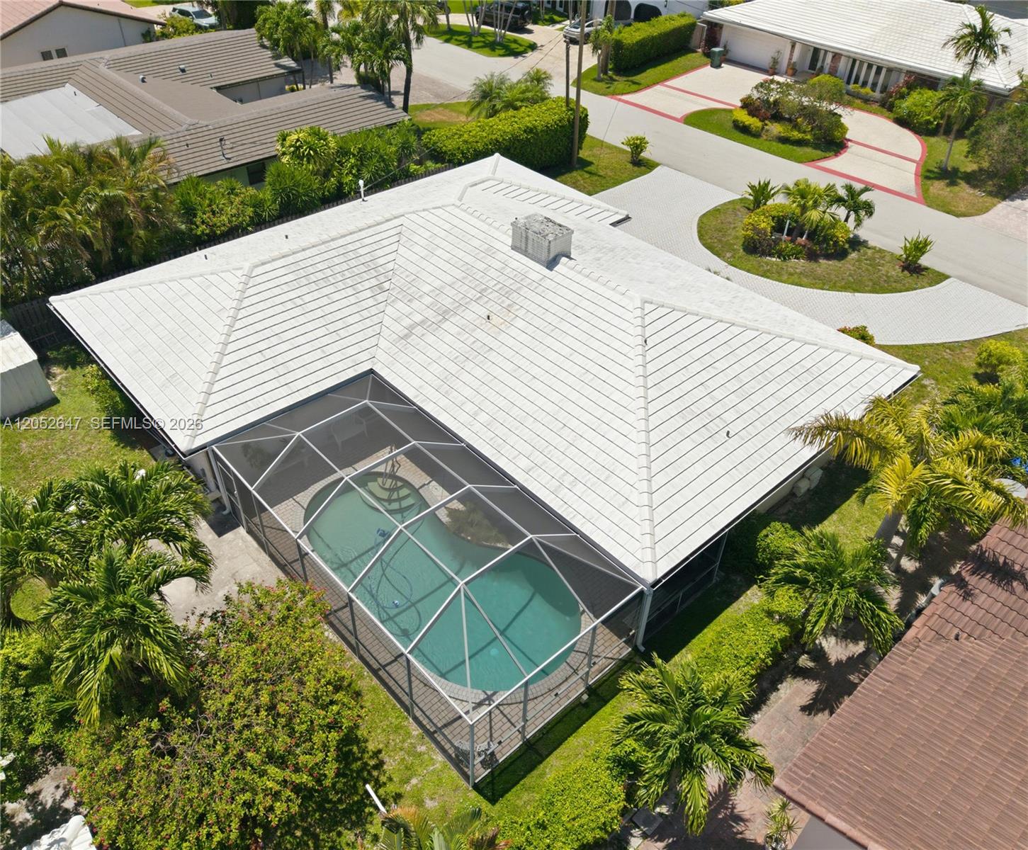 An aerial view shows a house with a white tiled roof and a screened-in pool — 8 Castle Harbor Is, Fort Lauderdale FL 33308, FORT LAUDERDALE, FL