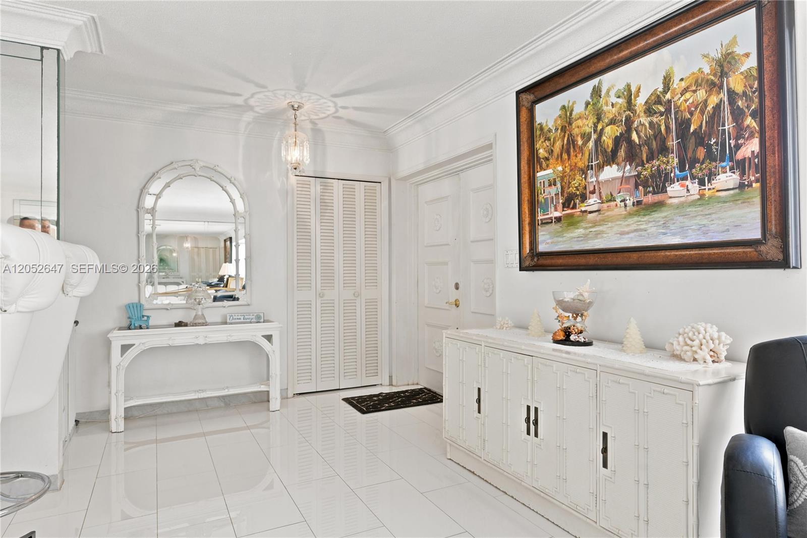 A bright entryway features white tile floors, a console table, a mirror, and wall art — 8 Castle Harbor Is, Fort Lauderdale FL 33308, FORT LAUDERDALE, FL