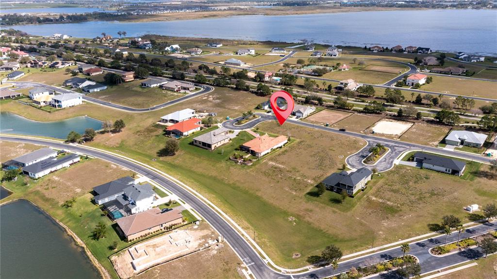 An aerial view shows a residential neighborhood with a red location pin over a house — 599 LOBLOLLY PLACE, AUBURNDALE, FL
