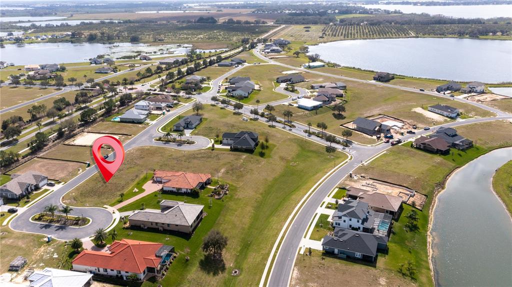 An aerial view shows a vacant residential lot marked with a red pin in a neighborhood — 599 LOBLOLLY PLACE, AUBURNDALE, FL