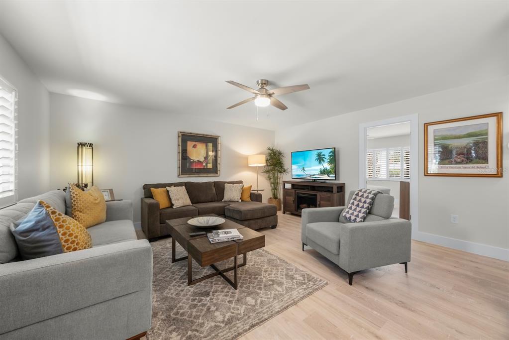 A living room features a sectional sofa, an armchair, a coffee table, and a television — 624 FLAMINGO DRIVE UNIT 112, VENICE, FL
