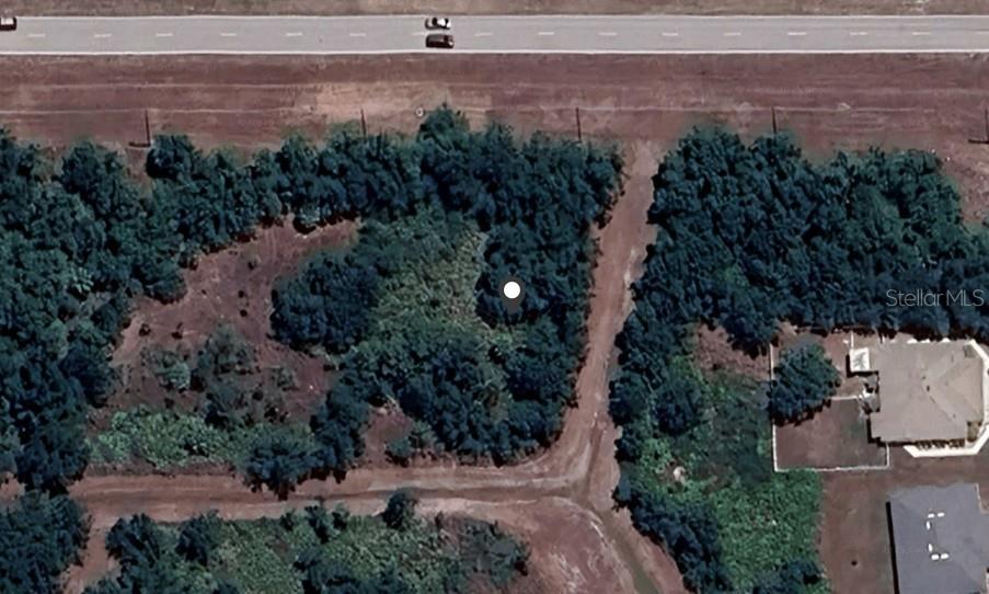 This is an aerial map view showing a wooded lot near a road and residential homes — 26271 SANDHILL BOULEVARD, PUNTA GORDA, FL
