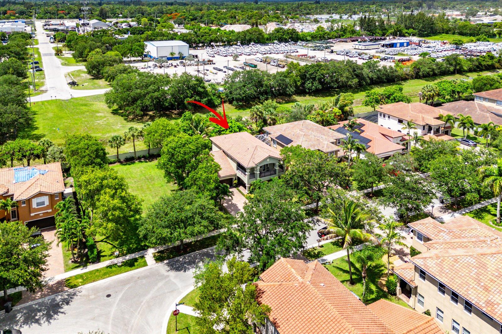An aerial view shows a two-story house with a tiled roof and a red arrow — 599 Cresta Circle, West Palm Beach FL 33413, WEST PALM BEACH, FL