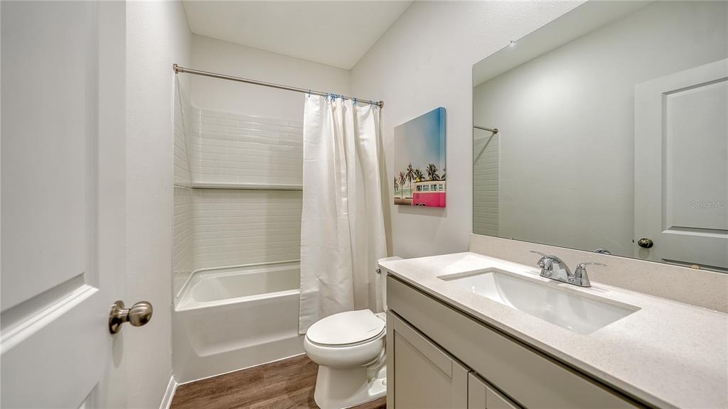 A bathroom features a vanity with a white countertop, a toilet, and a shower-tub combo — 12919 RED DEER PLACE, PARRISH, FL