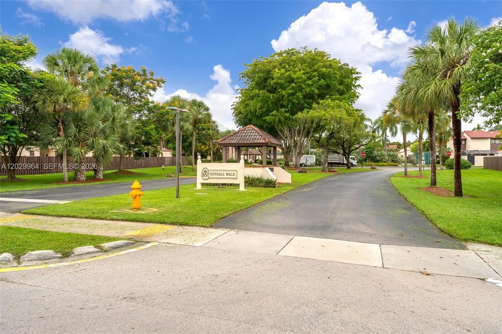 An entrance sign for Kendall Walk stands near a paved driveway and a small gazebo — 14932 SW 89th St, Miami FL 33196, MIAMI, FL