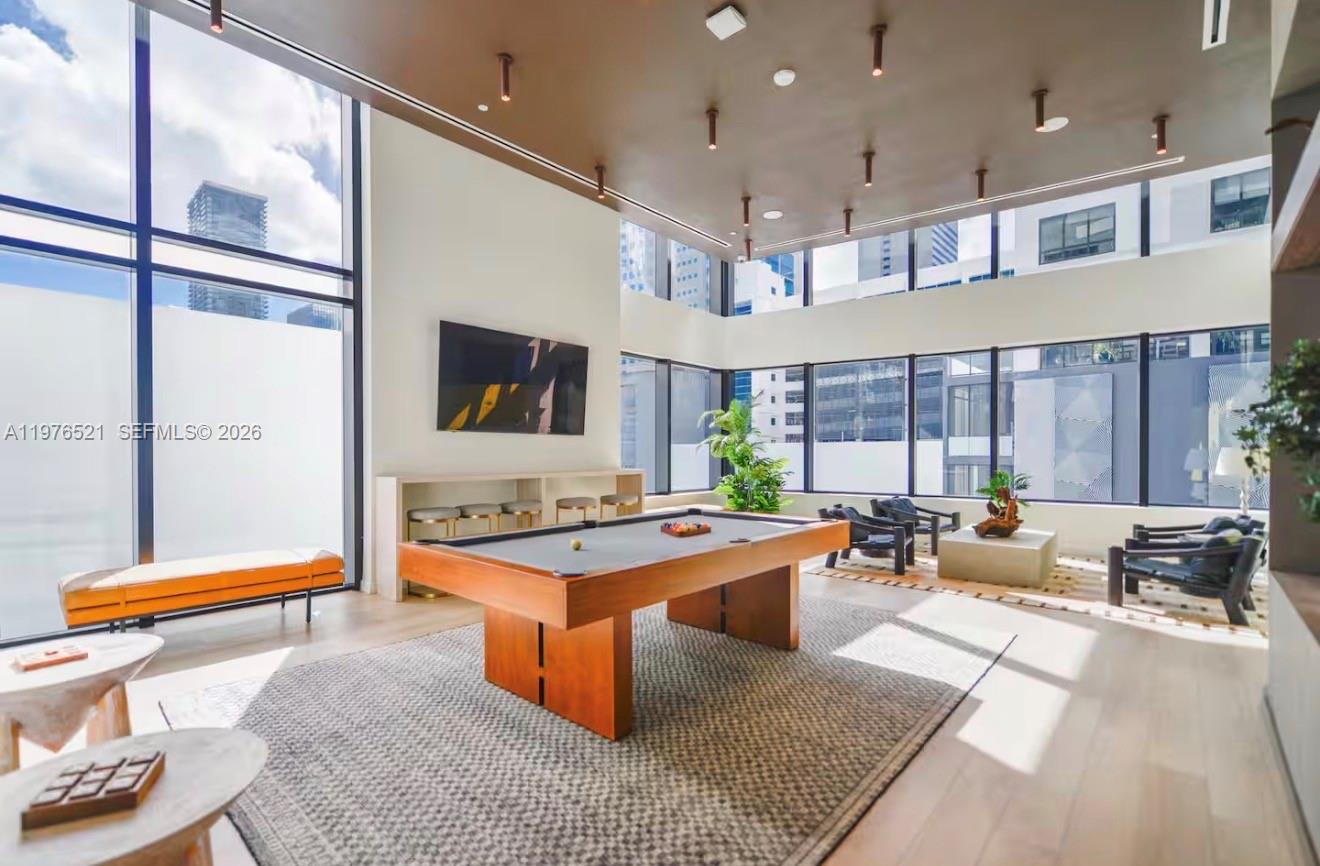 A spacious lounge features a pool table, floor-to-ceiling windows, and modern recessed ceiling lighting — 225 N Miami Ave # 1103, Miami FL 33128, MIAMI, FL