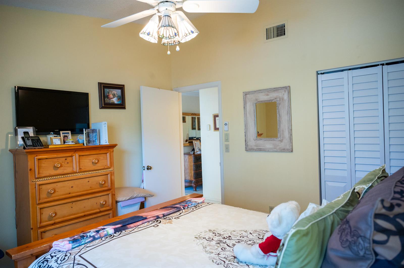 A bedroom features a wooden dresser, a ceiling fan, a bed, and a doorway — 7551 CAESAR Street # C, Lake Worth FL 33467, LAKE WORTH, FL