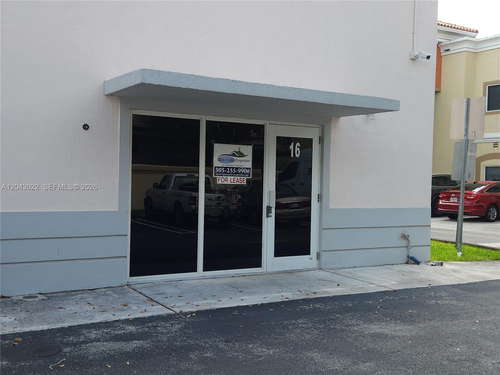 The exterior of a commercial building unit features a glass door labeled 16 and windows — 13331 SW 132 AVE # 16, Miami FL 33186, MIAMI, FL