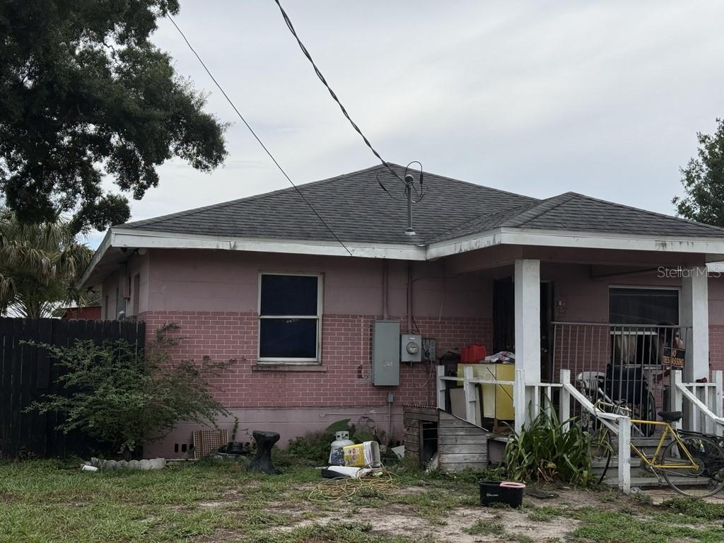 A pink, single-story house with a brick lower facade and a covered front porch — 5207 E 20TH AVENUE, TAMPA, FL