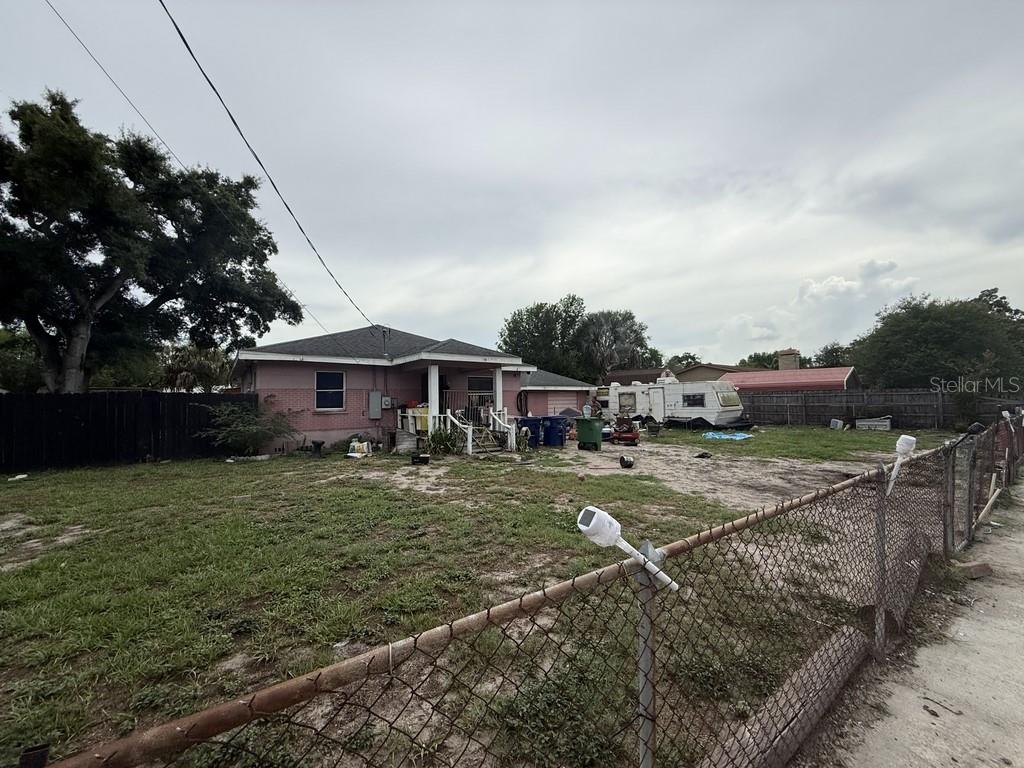 A pink single-story house with a porch sits on a lot with a parked camper — 5207 E 20TH AVENUE, TAMPA, FL