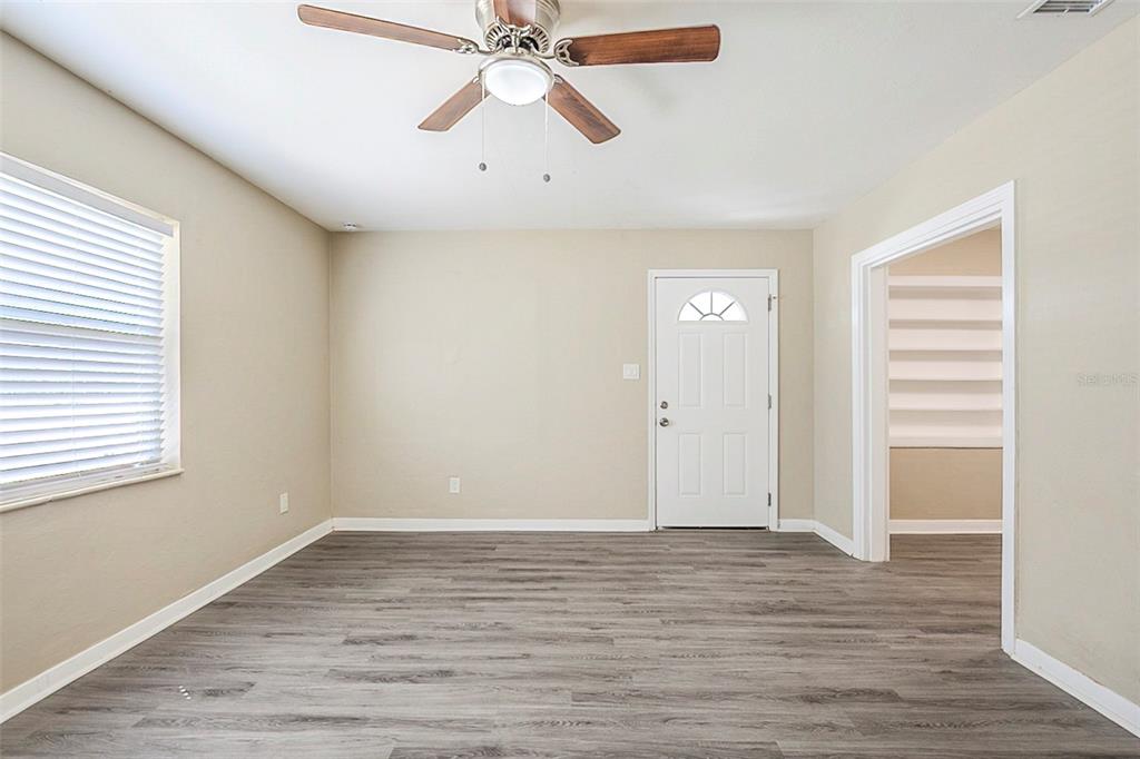A room with light-colored walls, gray wood-look flooring, a ceiling fan, and a white door — 3645 6TH STREET S, ST PETERSBURG, FL