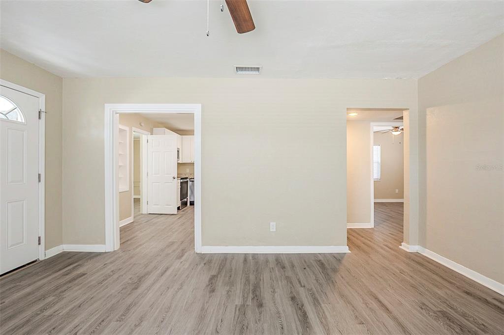 An interior view of a living area with light wood-look flooring and two doorways — 3645 6TH STREET S, ST PETERSBURG, FL