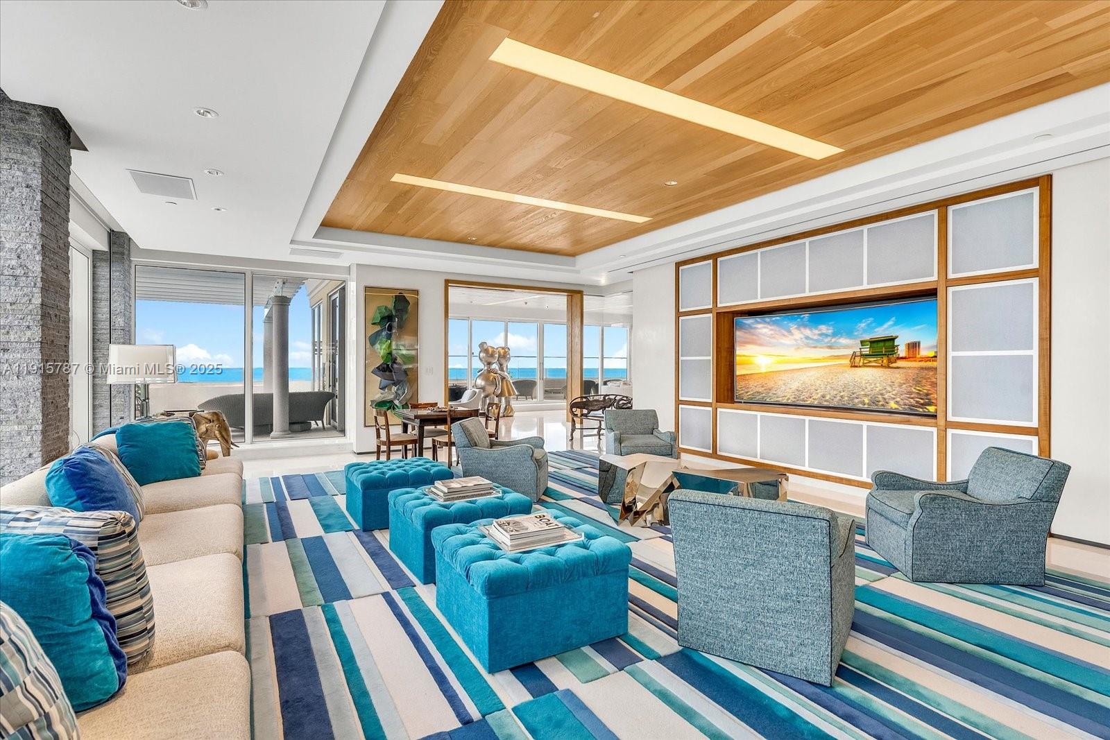 A living room features a large television, blue furniture, and a wood-paneled ceiling — 430 Grand Bay Dr, Key Biscayne FL 33149, KEY BISCAYNE, FL