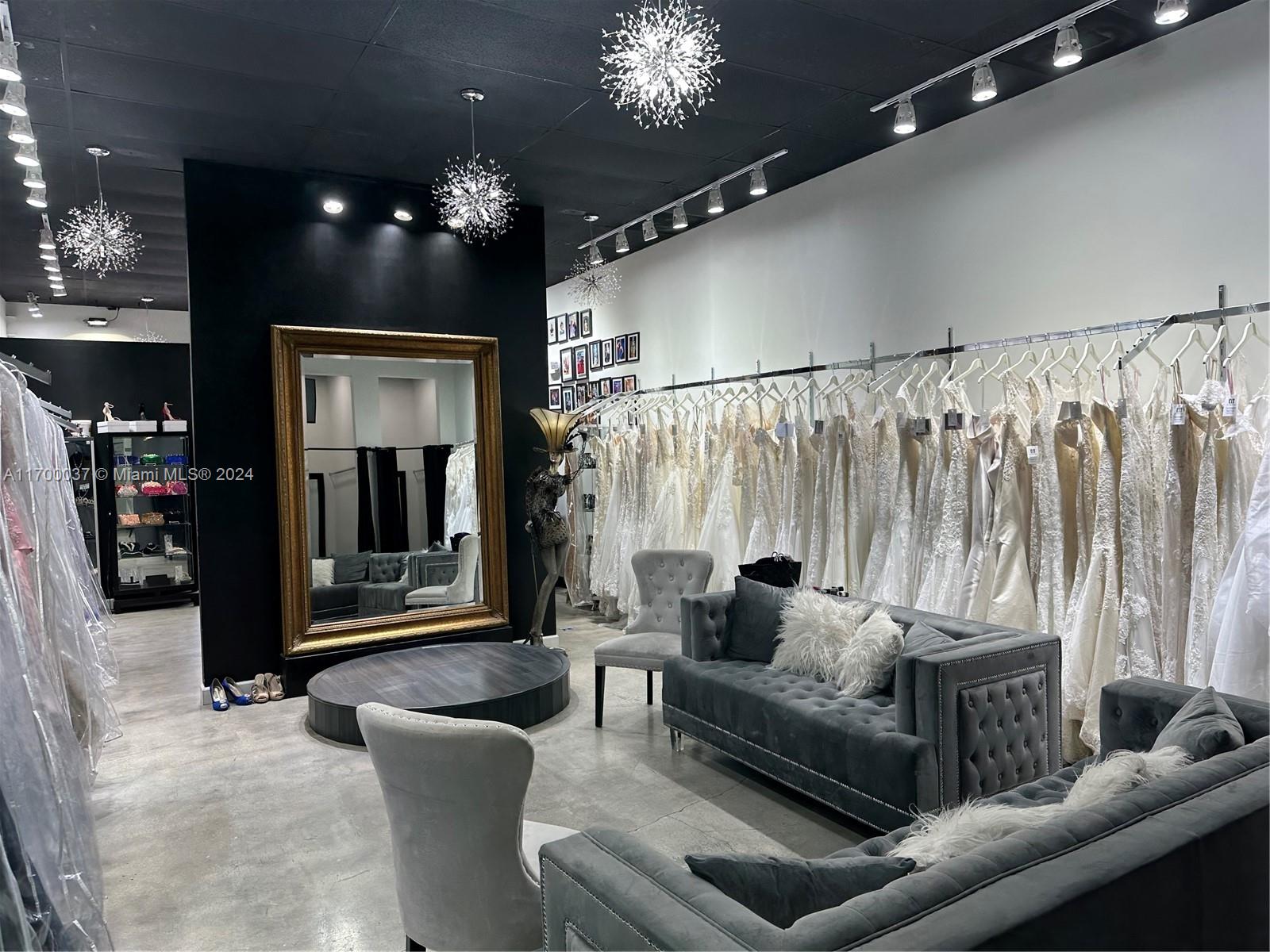 A bridal boutique features rows of wedding dresses, tufted grey sofas, and a large mirror — 14248 SW 8th St, Miami FL 33184, MIAMI, FL