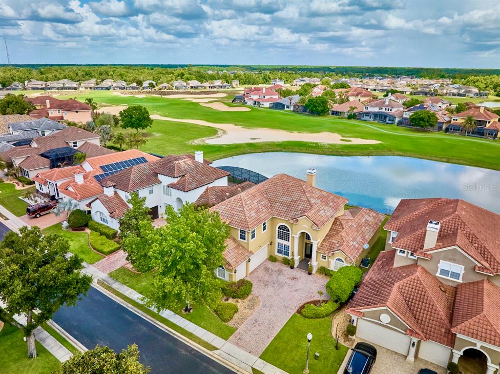 An aerial view shows several suburban homes situated along a pond and a golf course — 2234 CALLAWAY COURT, DAVENPORT, FL