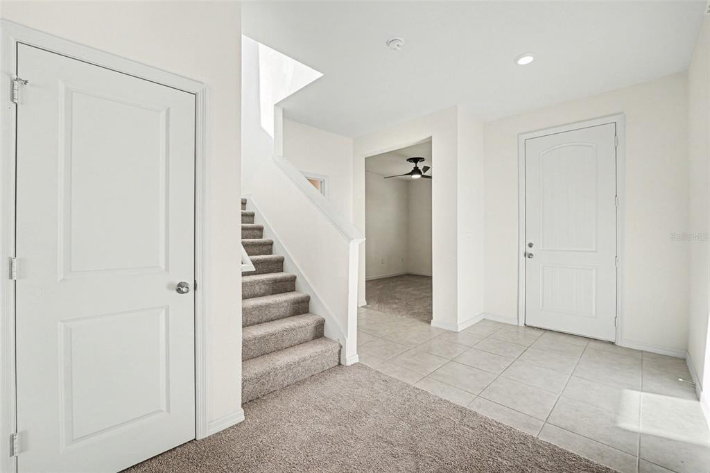 An entryway with tiled flooring, a carpeted staircase, and white interior doors — 2312 BISCOTTO CIRCLE, DAVENPORT, FL
