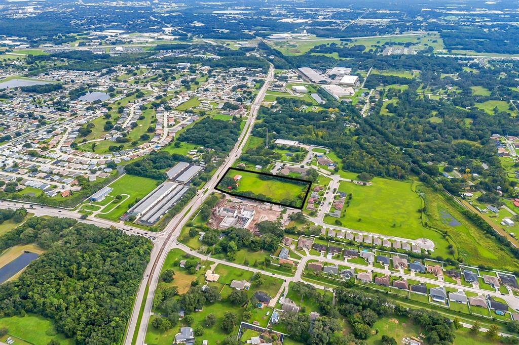 An aerial view shows a rectangular plot of land outlined in black near a highway — 3720 KATHLEEN ROAD, LAKELAND, FL