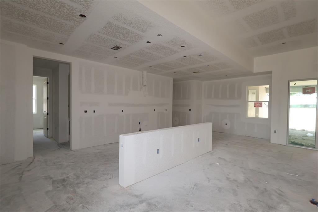 A modern kitchen features white cabinetry, a large quartz island, and light wood flooring — 3254 WOLF LAKE AVENUE, APOPKA, FL