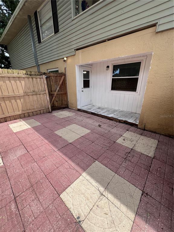 A paved patio area sits beside a house with a white door and window — 226 THORN TREE PLACE UNIT 226, BRANDON, FL
