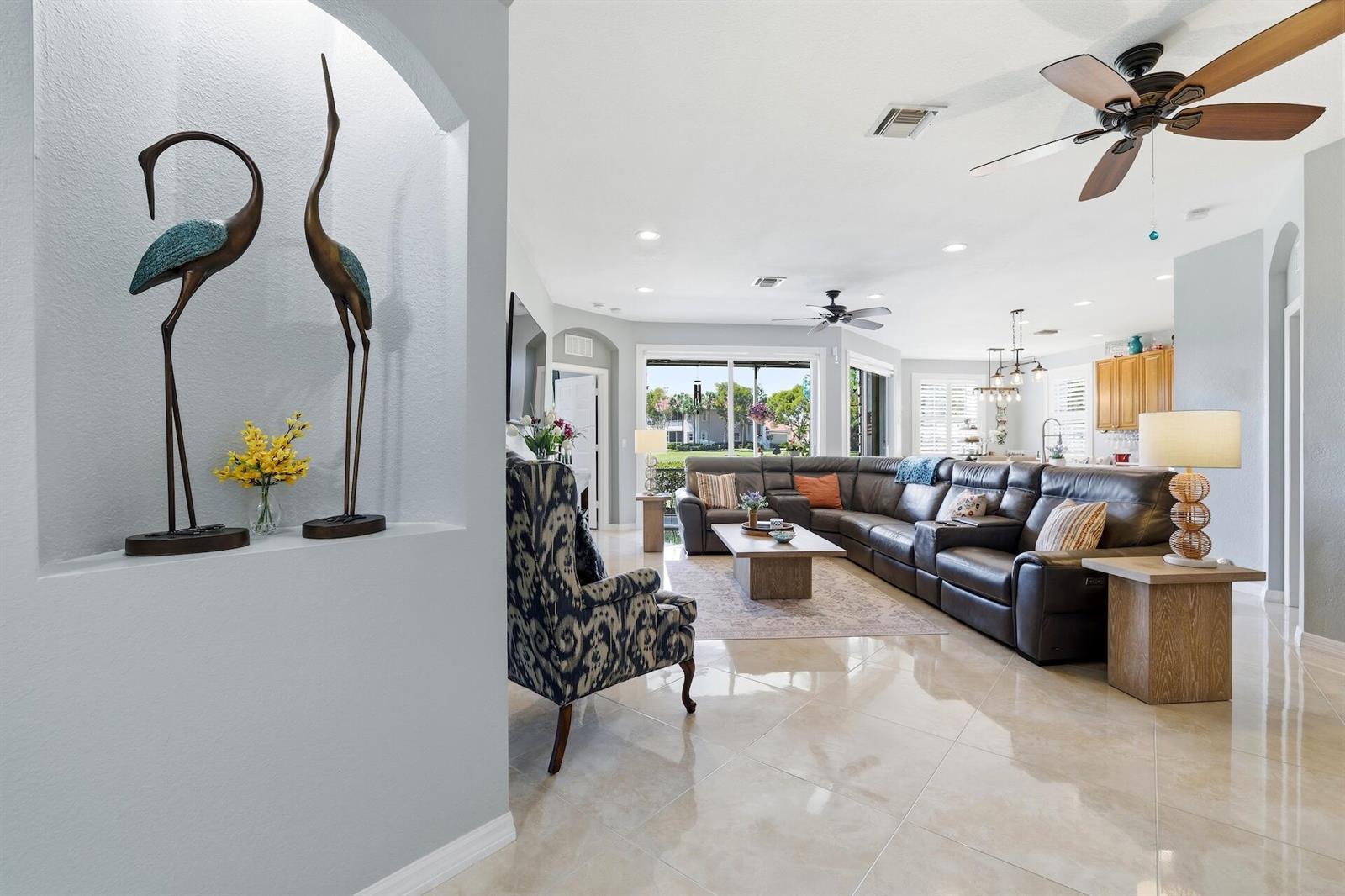 A living room features a large sectional sofa, tile flooring, and a decorative arched niche — 2101 Wingate Bend, Wellington FL 33414, WELLINGTON, FL