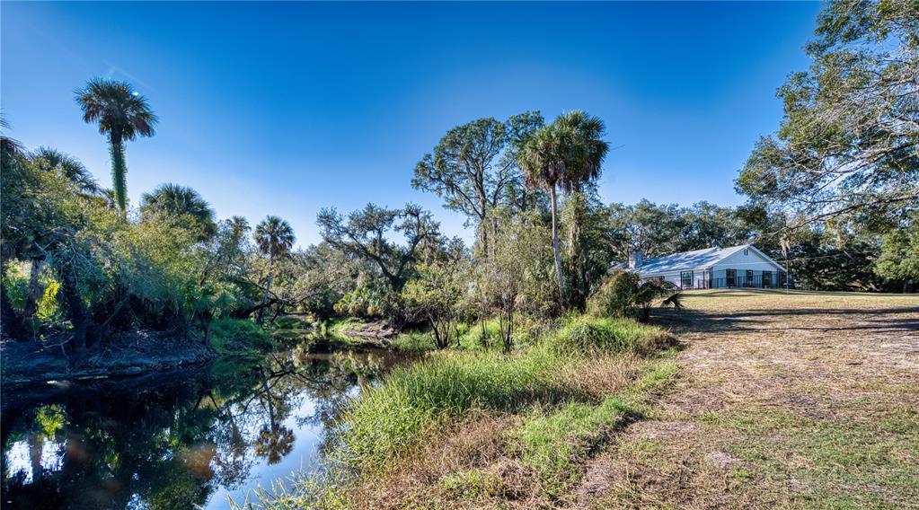 Aerial view of a house with a pool and outbuildings on a wooded lot — 5310 JIM DAVIS ROAD, PARRISH, FL