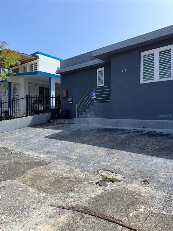 A gray exterior building with a concrete driveway and a metal staircase leading to the entrance — 417 ESCORIAL AVENUE, SAN JUAN, PR