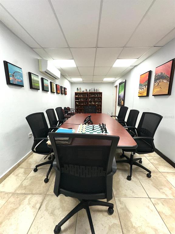 A conference room features a long table with a chessboard, surrounding chairs, and wall art — 417 ESCORIAL AVENUE, SAN JUAN, PR