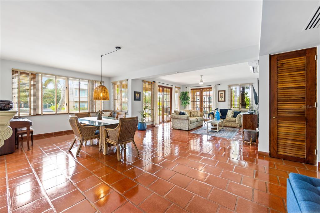 An open-concept living and dining area features terracotta tile flooring and large windows — E LAKESIDE VILLAS UNIT 1, VEGA ALTA, PR