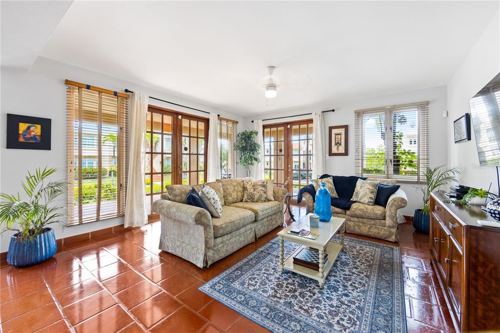 A living room features terracotta tile floors, two patterned sofas, and glass-paned double doors — E LAKESIDE VILLAS UNIT 1, VEGA ALTA, PR