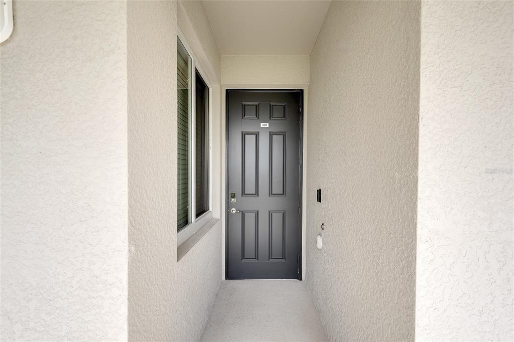 A dark gray front door with a small number plate sits at the end of a recessed entryway — 850 TIDEWATER SHORES LOOP UNIT 402, BRADENTON, FL