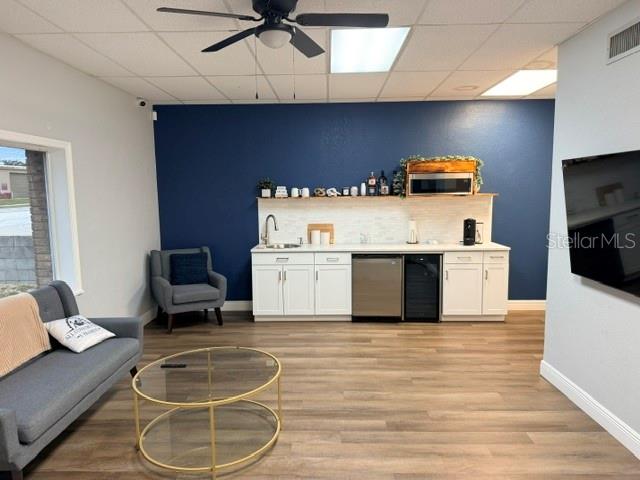 A breakroom features a kitchenette with white cabinets, a dark blue wall, and seating area — 223 COMMONWEALTH AVENUE SW, POLK CITY, FL