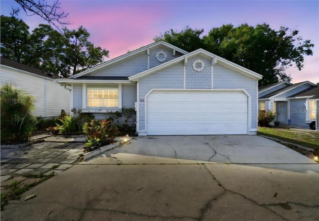 A light blue single-story house with a two-car garage and a concrete driveway — 106 LAMPLIGHTER DRIVE, SANFORD, FL