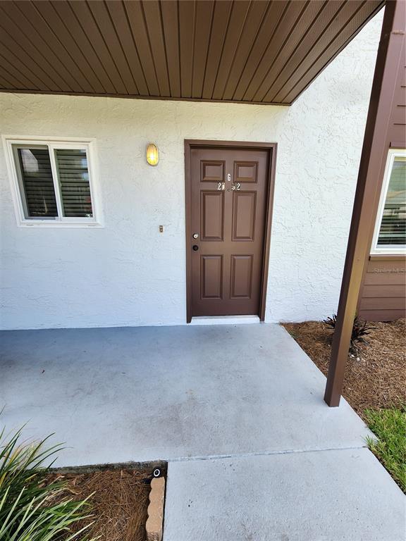 A brown front door with the number 6 above it sits on a concrete porch — 39132 COUNTY ROAD 54 UNIT 2152, ZEPHYRHILLS, FL