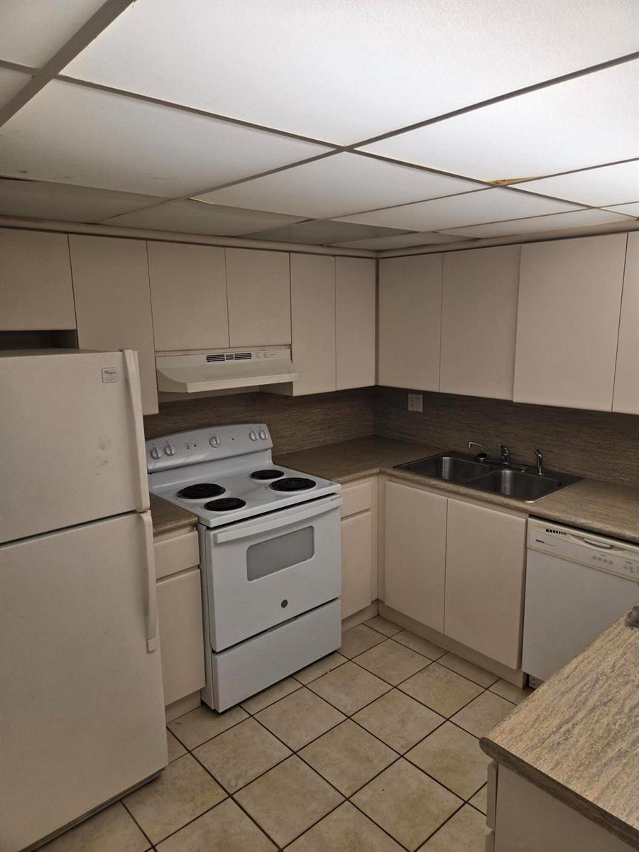 A kitchen features white cabinets, white appliances, a double sink, and light-colored tile flooring — 3714 SW 60th Terrace # 28, Davie FL 33314, DAVIE, FL