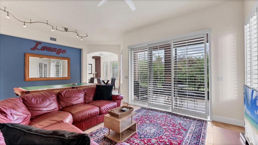 A living room features a red leather sectional, a pool table, and sliding glass doors — 5433 46TH COURT W, BRADENTON, FL
