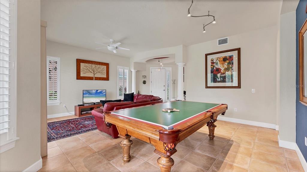 A game room features a pool table with a ping pong top and a seating area — 5433 46TH COURT W, BRADENTON, FL