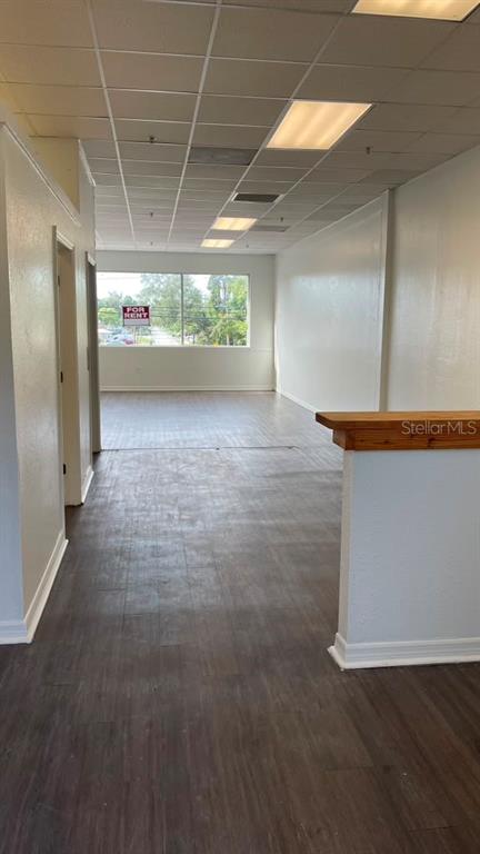 An empty commercial space features dark wood-look flooring, white walls, and a drop ceiling — 1412 W WATERS AVENUE UNIT 202, TAMPA, FL