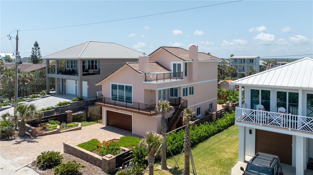 An aerial view shows several beach houses with driveways and yards along a sandy coastline — 6260 S ATLANTIC AVENUE, NEW SMYRNA BEACH, FL