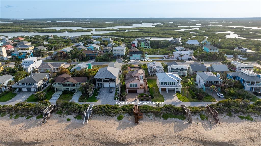 A two-story house with a garage, a large balcony, and a stone retaining wall — 6260 S ATLANTIC AVENUE, NEW SMYRNA BEACH, FL