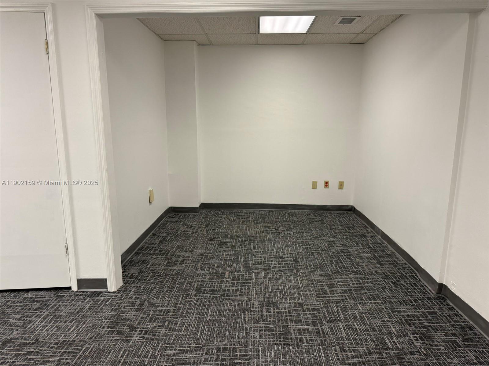 An empty office space features white walls, gray patterned carpet, and a drop ceiling — 220 Miracle Mile, Coral Gables FL 33134, CORAL GABLES, FL