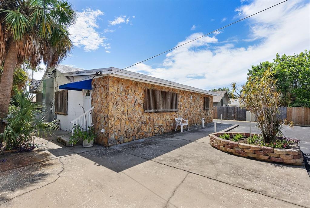 A single-story building with a stone facade, a blue awning, and a concrete parking area — 3425 22ND AVENUE S, ST PETERSBURG, FL